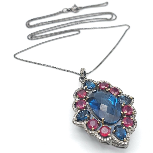 734B - This Blue Topaz, Ruby & Diamond, Sterling Silver Pendant Necklace is a jaw-dropper. 
With 30cts of B... 