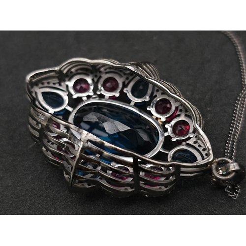 734B - This Blue Topaz, Ruby & Diamond, Sterling Silver Pendant Necklace is a jaw-dropper. 
With 30cts of B... 