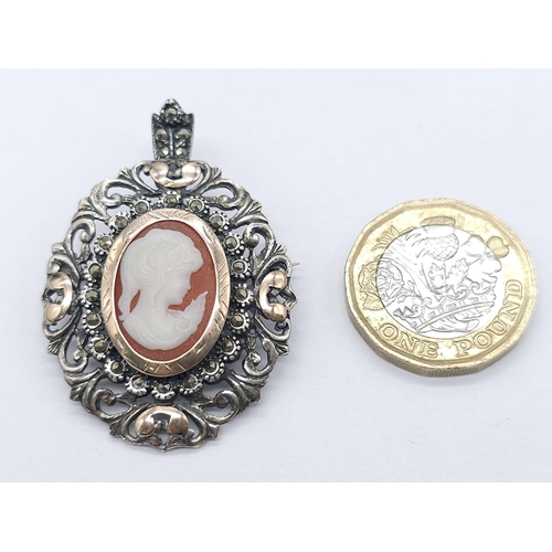 660B - An Antique Silver and Rose Gold Decorative Cameo Brooch. 
Central small cameo with a rose gold halo ... 