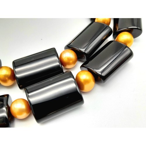 485 - A Sophisticated Looking Cultured Golden Pearl and Black Elongated Acrylic Bead Necklace. 50cm