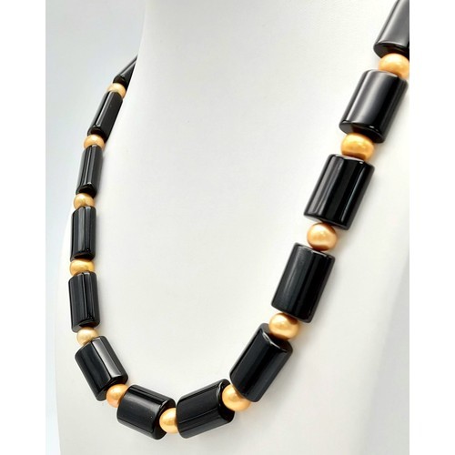 485 - A Sophisticated Looking Cultured Golden Pearl and Black Elongated Acrylic Bead Necklace. 50cm