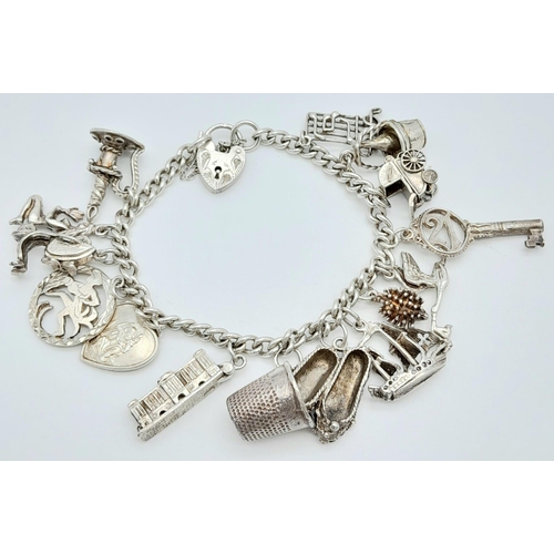 56 - A vintage sterling silver multiple charms bracelet such as ship, thimble, classic motives, etc. Tota... 