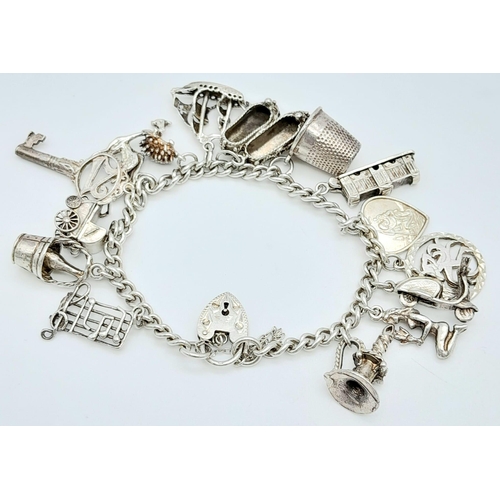 56 - A vintage sterling silver multiple charms bracelet such as ship, thimble, classic motives, etc. Tota... 