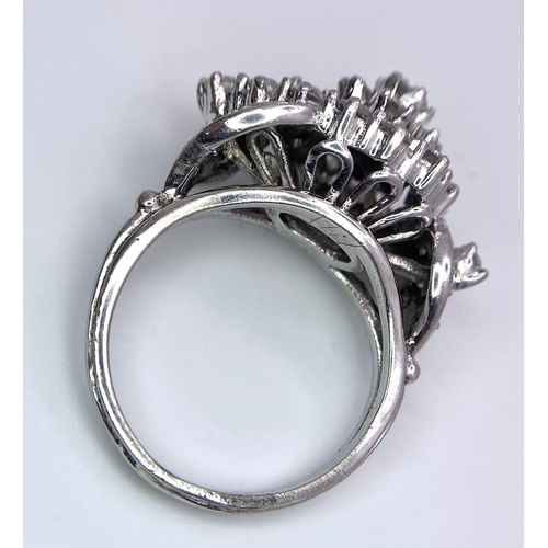 938B - A Fancy Cluster Ring - Set with 1.1ctw of round cut diamonds. Set in white metal. Size O