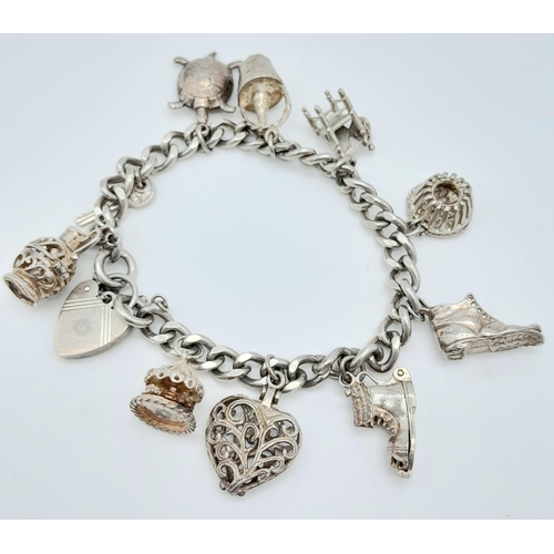 284 - A vintage sterling silver bracelet with multiple charms such as filigree heart, carousel, etc. Total... 