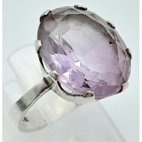 311 - A vintage sterling silver faceted Amethyst solitaire ring. Total weight 4.4G. Size O.