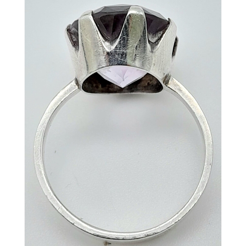 311 - A vintage sterling silver faceted Amethyst solitaire ring. Total weight 4.4G. Size O.