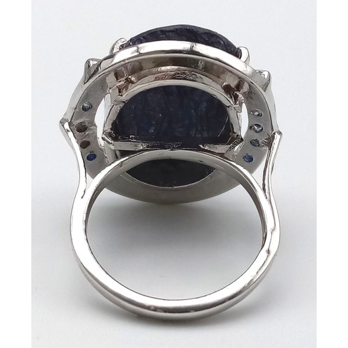 655B - A Blue Sapphire and 925 Silver Ring. Oval cut central sapphire with small sapphire accents. Size R. ... 