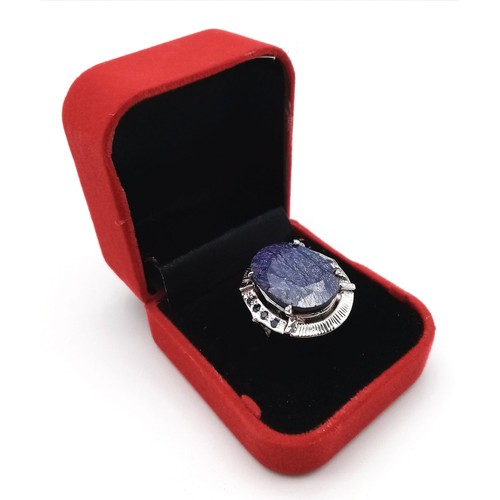 655B - A Blue Sapphire and 925 Silver Ring. Oval cut central sapphire with small sapphire accents. Size R. ... 