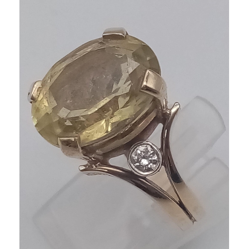 183 - A 9K Yellow Gold Citrine and Diamond Ring. Large central oval citrine with a round cut diamond eithe... 