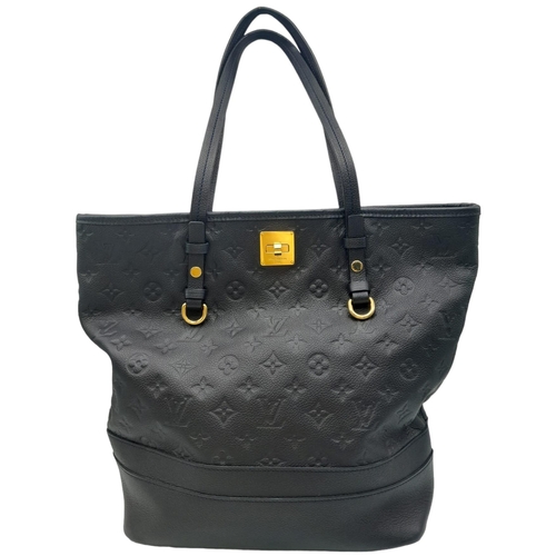 200 - A Louis Vuitton Monogram Empreinte PM Tote Bag. Navy blue exterior with gold tone hardware. Spacious... 