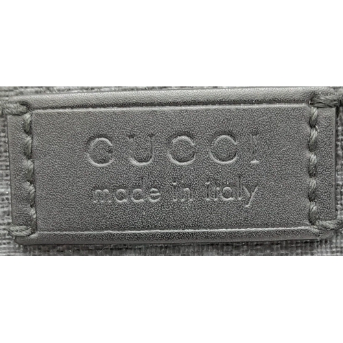 270 - A Gucci Monogram Messenger Bag. GG grey canvas exterior wit black leather accents and zipped compart... 