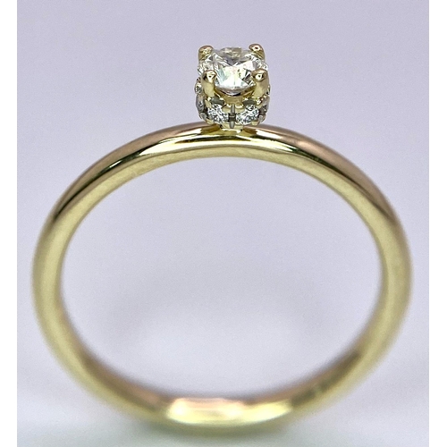 349 - A 9 K yellow gold ring with a brilliant cut diamond (0.25 carats) standing proud and a halo of diamo... 