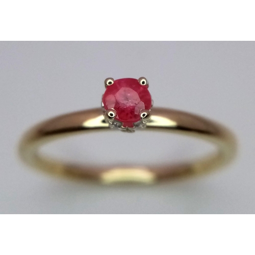 363 - A 9 k yellow gold ring with a ruby standing proud on a halo of diamonds. ring size: O, weight: 2 g.