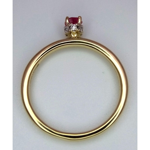 363 - A 9 k yellow gold ring with a ruby standing proud on a halo of diamonds. ring size: O, weight: 2 g.