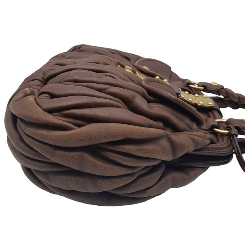 382 - A Miu Miu Brown Leather Handbag. Ruffled leather exterior with two pocketed compartments. Gold tone ... 