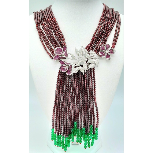 1274 - A statement necklace consisting of eleven strands of round garnets with a spectacular central floral... 