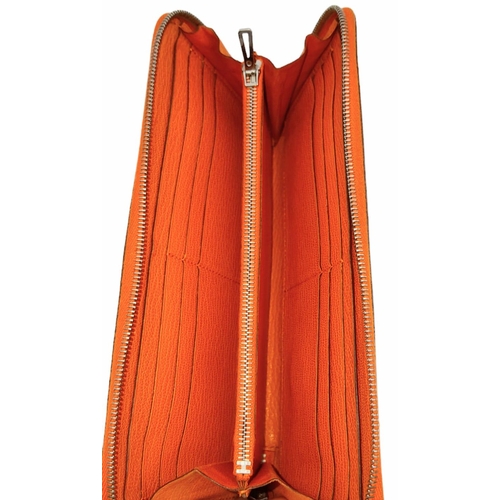 452 - A Hermes Burnt Orange Leather Wallet. Burnt orange leather interior with zipped and open compartment... 