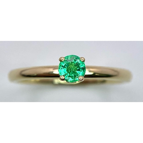 370 - A 9 K yellow gold ring with a single round cut quality emerald standing proud and a halo of diamonds... 