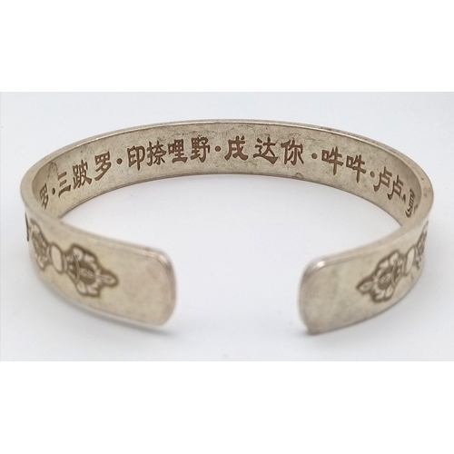 297 - A Tibetan silver bangle with Tibetan language characters on the outside and Chinese language charact... 