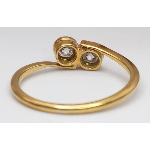 107 - An 18 K yellow gold ring with a pair of two quality round cut diamonds (total 0.60 carats appr), siz... 