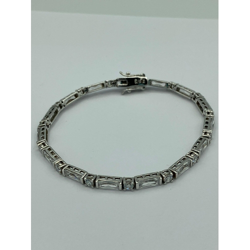 259 - Hallmarked SILVER TENNIS BRACELET set with sparkling Princess cut and Round cut Zirconias. 19 cm.