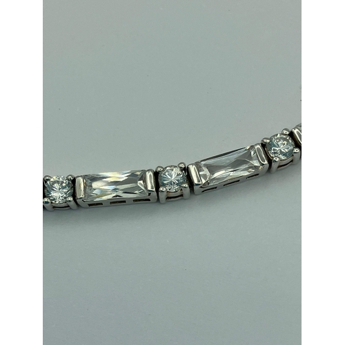 259 - Hallmarked SILVER TENNIS BRACELET set with sparkling Princess cut and Round cut Zirconias. 19 cm.