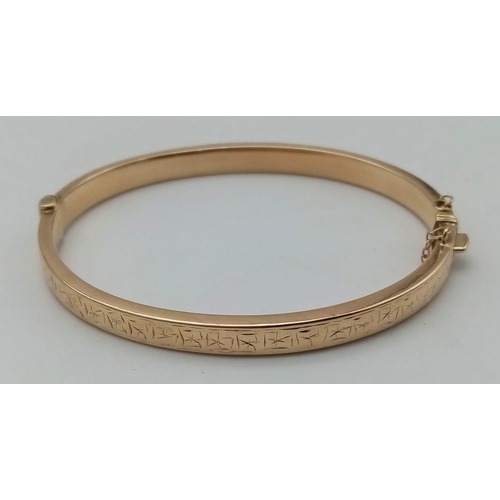 396 - A 9 K yellow gold bangle with an ornamental engraving on the top side. Clasp in good working order. ... 