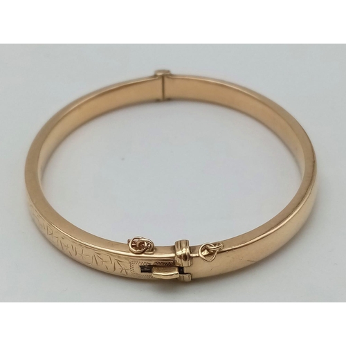 396 - A 9 K yellow gold bangle with an ornamental engraving on the top side. Clasp in good working order. ... 