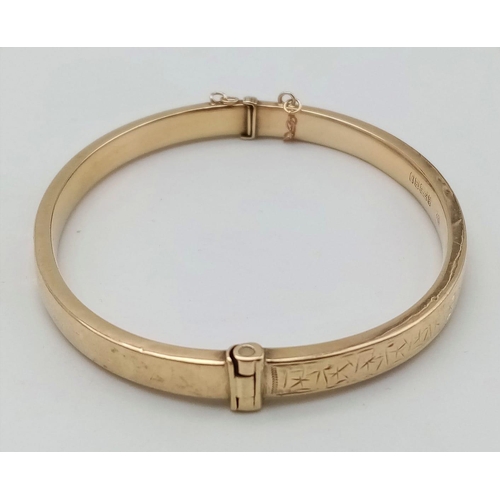 396 - A 9 K yellow gold bangle with an ornamental engraving on the top side. Clasp in good working order. ... 