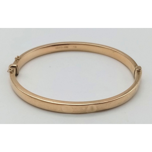 396 - A 9 K yellow gold bangle with an ornamental engraving on the top side. Clasp in good working order. ... 