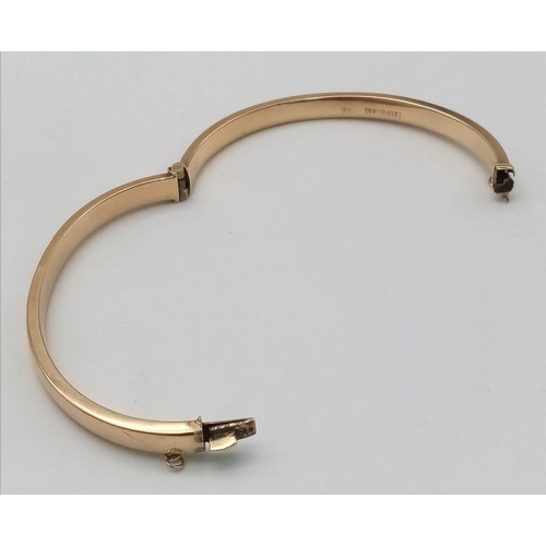 396 - A 9 K yellow gold bangle with an ornamental engraving on the top side. Clasp in good working order. ... 