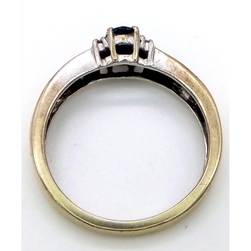 100 - A 9 K white gold on yellow gold ring with dark blue sapphires. Ring size: M1/2, weight: 2.4 g.