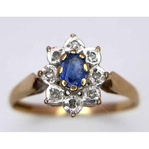 225 - A 9 K yellow gold ring with an oval cut sapphire surrounded by a halo of diamonds. Ring size: N, wei... 