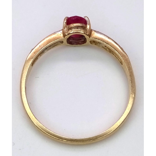 232 - A 9 K yellow gold ring with an oval cut natural ruby and a band of diamonds on each shoulder of the ... 