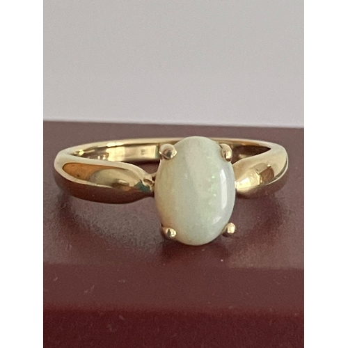 434 - 9 carat GOLD and OPAL RING. Consisting a plain YELLOW GOLD BAND set with an oval lab Opal. Complete ... 