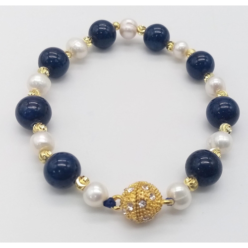 1573 - A Lapis Lazuli and Cultured Pearl Bracelet. Gilded clasp and spacers. 18cm