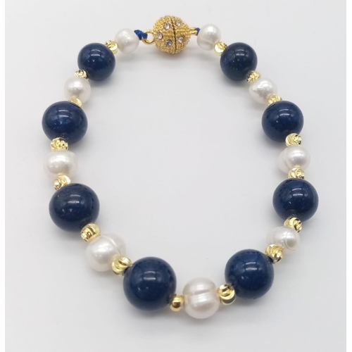 1573 - A Lapis Lazuli and Cultured Pearl Bracelet. Gilded clasp and spacers. 18cm