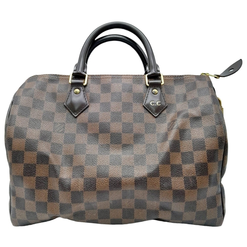 36 - A Louis Vuitton Speedy Bag. Checked LV canvas exterior. Red textile interior. Comes with dust cover,... 