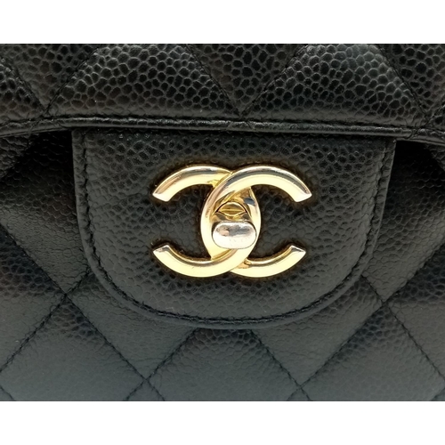 3 - A Chanel Black Caviar Classic Double Flap Bag. Quilted pebbled leather exterior with gold-toned hard... 