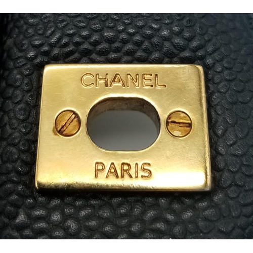 3 - A Chanel Black Caviar Classic Double Flap Bag. Quilted pebbled leather exterior with gold-toned hard... 