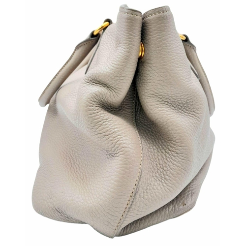 510 - A Prada Vitello Daino Tote Pomice Bag. Textured leather exterior with gold-tone hardware. Decorative... 