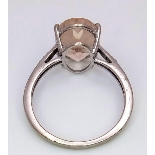 541 - A 9K WHITE GOLD DIAMOND & PEACH STONE SET COCKTAIL RING. 3.5G. SIZE R.