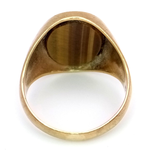 317 - A GENTS 9K GOLD SIGNET RING WITH TIGERS EYE CENTRE STONE  .    5.4gms   size R