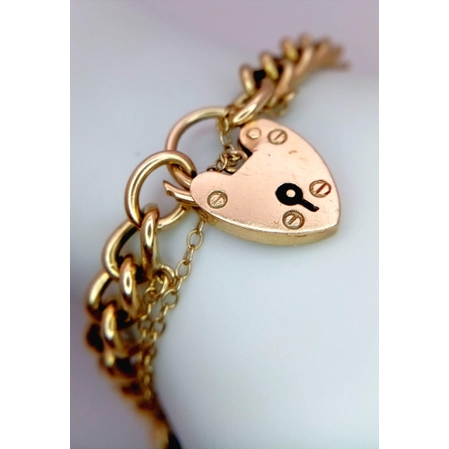 323 - A HEAVY 9K GOLD INTERLINK BRACELET WITH HEART PADLOCK AND SAFETY CHAIN .  22.6gms   18cms