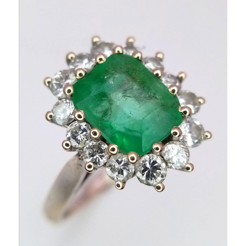 101 - AN 18K WHITE GOLD DIAMOND & EMERALD CLUSTER RING. 0.50CT DIAMONDS & APPROX 2CT EMERALD. 3.6G. SIZE M