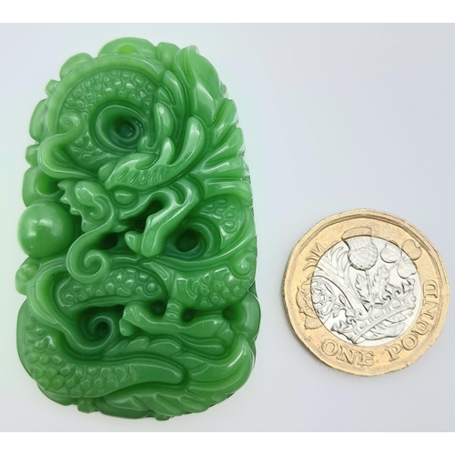 1406 - A Chinese Green Jade Decoratively Carved Dragon Pendant. 5.5cm