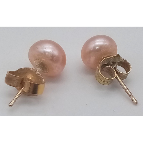 1170 - A 9 K yellow gold pair of stud earrings with a natural round pink pearl each, total weight: 1.5 g.