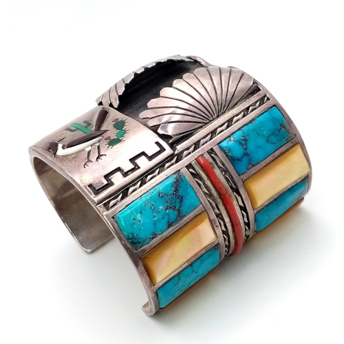 143 - A Vintage Silver Native American Cuff Bangle. Inlaid turquoise, mother of pearl and red coral create... 