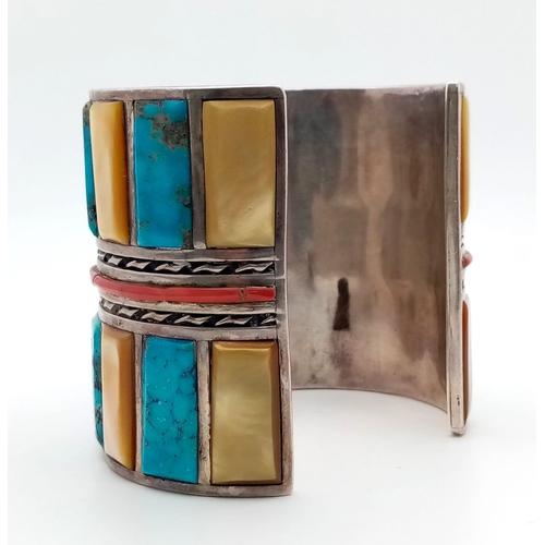 143 - A Vintage Silver Native American Cuff Bangle. Inlaid turquoise, mother of pearl and red coral create... 